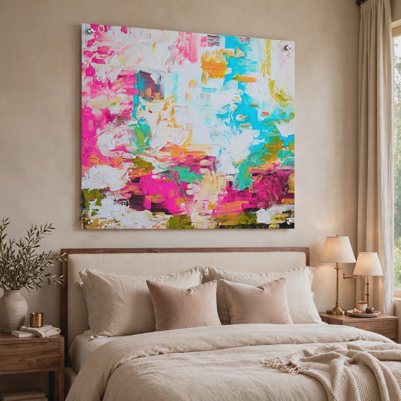 May include: A large square wall art piece featuring an abstract composition with thick, textured paint strokes in vibrant shades of hot pink, bright turquoise, sunny yellow, and white, mounted with four silver hardware standoffs at the corners.