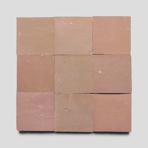 May include: A grid of nine square terracotta tiles arranged in a three-by-three pattern. Each tile features a matte, earthy reddish-brown surface with subtle variations in tone, small natural surface imperfections, and straight, defined edges.