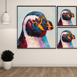 May include: A set of three framed penguin paintings. The central painting is a close-up of a penguin's head, showcasing vibrant brushstrokes in shades of blue, red, yellow, and white. The smaller paintings feature the same penguin image.