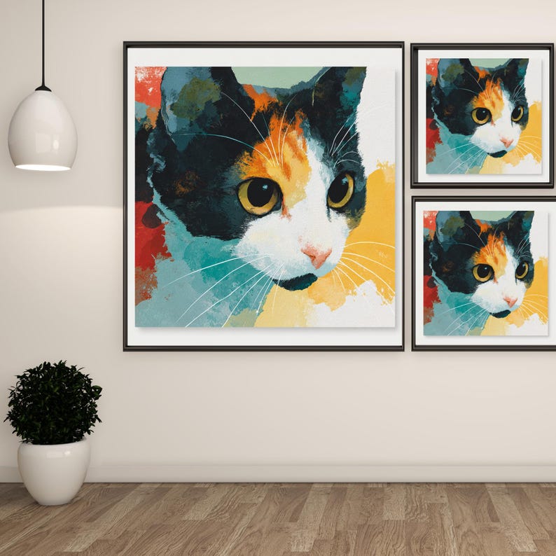 May include: A set of three framed cat art prints. The artwork depicts a close-up of a calico cat's face with black, orange, white, and yellow colours. The cat's eyes are yellow, and the background has a watercolour effect.