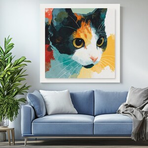 May include: A framed art print depicting a cat's face in an abstract style. The cat has black, orange, and white fur, with large yellow eyes and long white whiskers. The background features splashes of red, blue, and yellow.