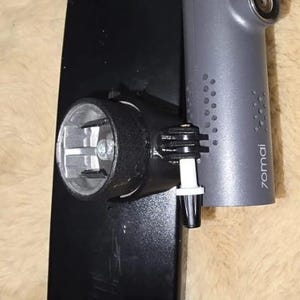 May include: A black rectangular rearview mirror attachment featuring a cylindrical grey 70mai dash camera mounted on the side. The camera unit has a visible lens, a series of small ventilation holes, and the brand name 70mai printed in white text.