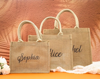 May include: Three rectangular jute tote bags with sturdy handles in varying sizes. Each bag features a natural tan woven texture and is personalized with black cursive text reading Sophia, Alice, and hel, arranged in a stepped formation.