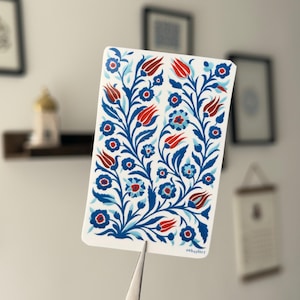 Könnte beinhalten: Eine weiße rechteckige Karte mit einem floralen Muster aus roten Tulpen, blauen Blumen und grünen Blättern. Das Design befindet sich auf weißem Hintergrund. Die Karte trägt den Text "subaylart" in der unteren rechten Ecke.