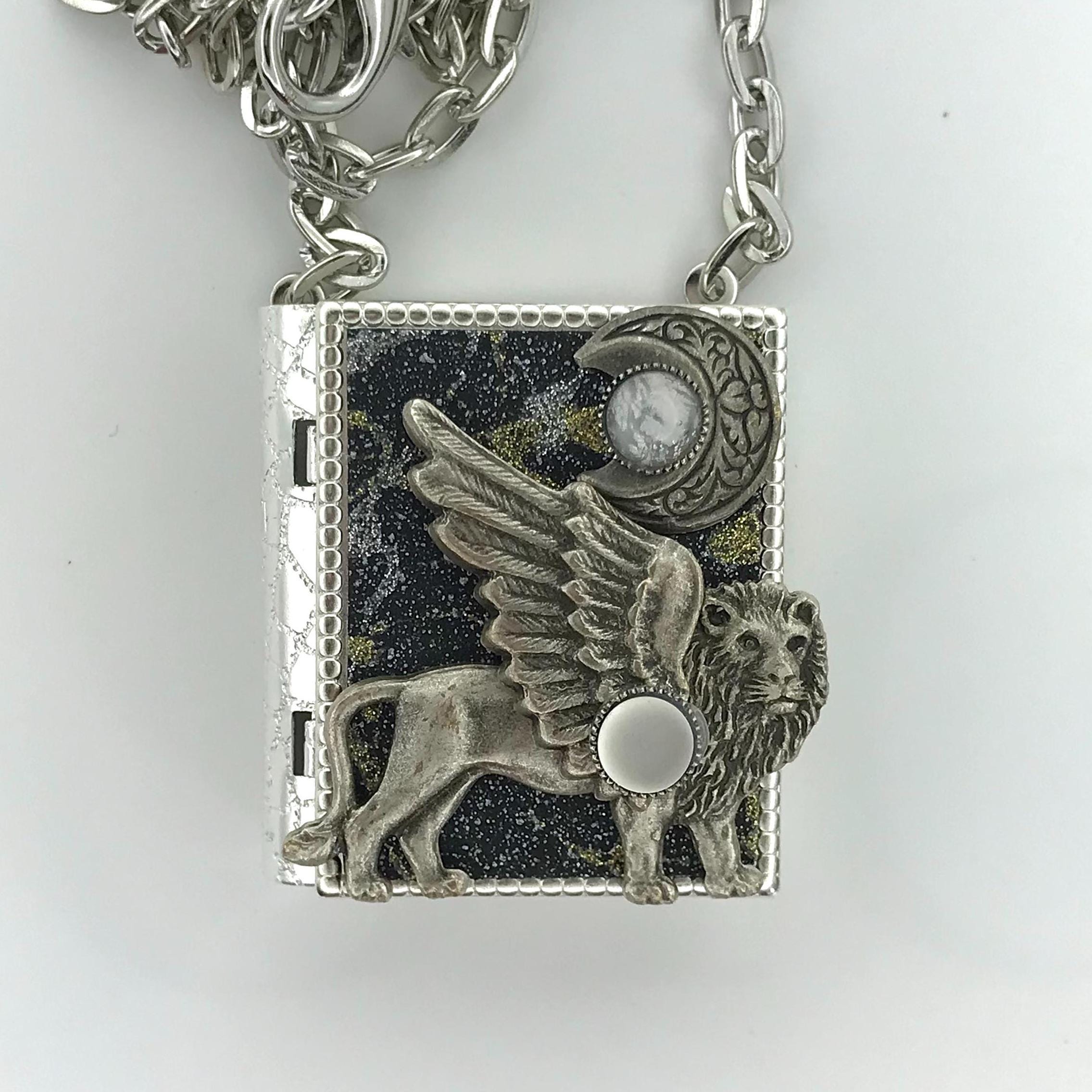 Miniature book necklace featuring an antique silver winged lion design on the cover, with a healing spell hidden inside