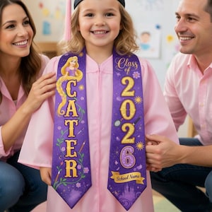 Op de afbeelding: Een jong kind in een roze afstudeerjurk en zwarte hoed lacht in de camera. Het kind draagt een paarse sjerp met gouden letters met de tekst "Class of 2026" en "CATER". Een vrouw en een man, beiden in roze shirts, flankeren het kind.