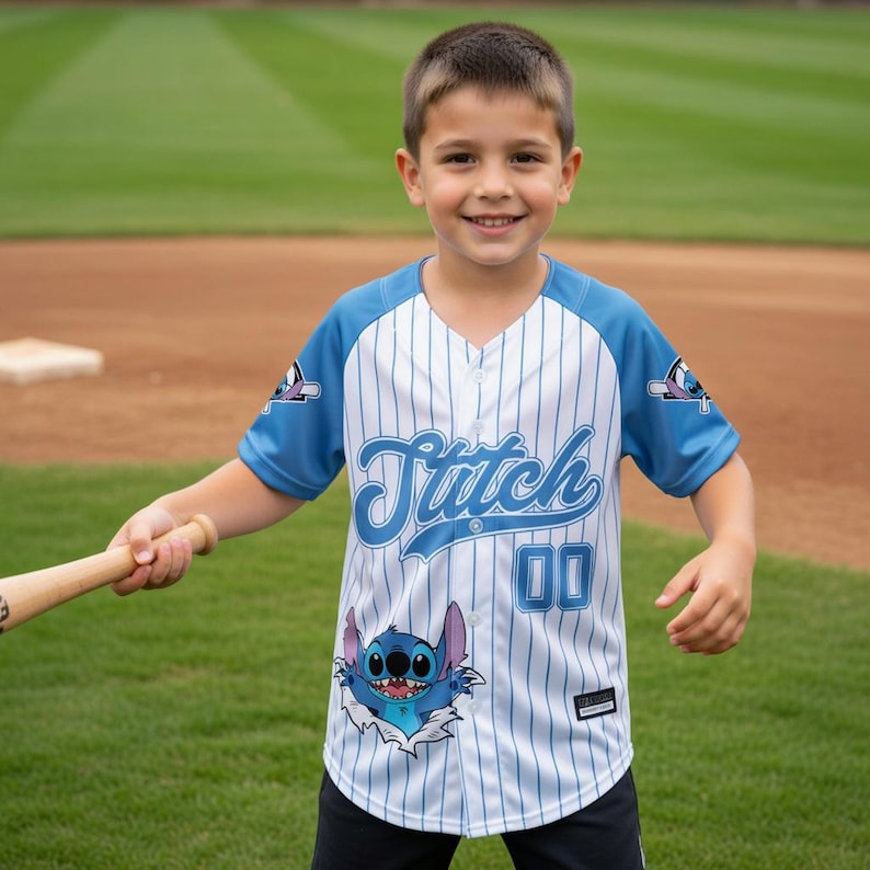 Peut inclure: Un maillot de baseball &agrave; rayures bleues et blanches, avec le mot "Stitch" en script bleu sur la poitrine et le num&eacute;ro "00". Le maillot a des manches bleues et une image de dessin anim&eacute; de Stitch sur le devant.