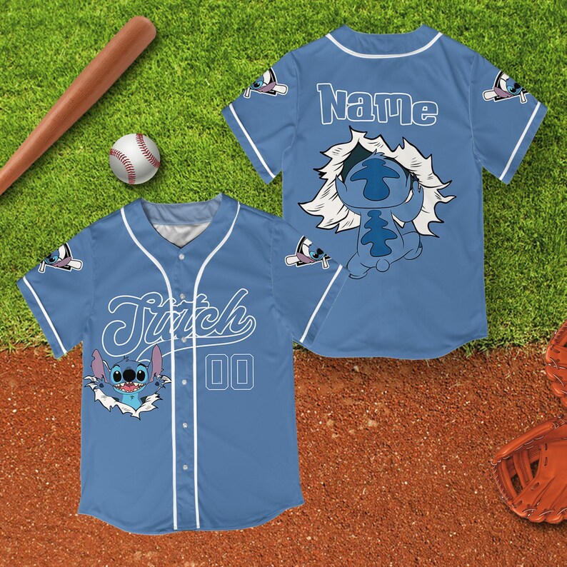 Peut inclure: Maillot de baseball bleu clair avec Stitch de Lilo & Stitch. Le maillot a des d&eacute;tails blancs, le nom "Stitch" et le num&eacute;ro "00" sur le devant. Le dos du maillot porte le nom "Name". Une batte et une balle de baseball sont en arri&egrave;re-plan.