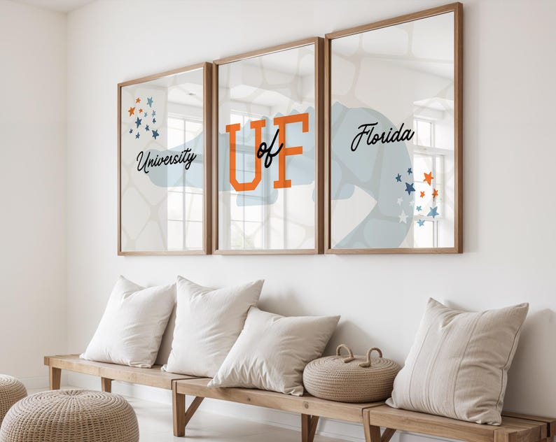 May include: Three framed prints with a blue and white abstract design. The middle print features the text "University of Florida" in black and orange lettering. The prints are hanging on a white wall above a wooden bench.