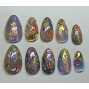 May include: A set of ten artificial nails with an oval shape. Each nail features a unique design with iridescent colors, including purple, gold, orange, and green. The designs vary, with some featuring swirls and others with floral-like patterns.