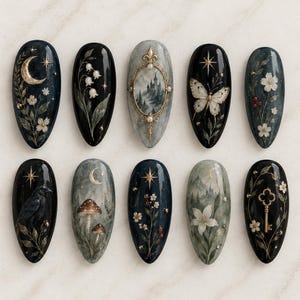 May include: A set of ten almond-shaped press-on nails featuring dark, moody designs including a crescent moon, lily of the valley, a castle in a gold frame, a butterfly, white flowers, a black raven, mushrooms, stars, a lily, and a gold key.