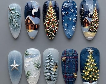 May include: A set of ten almond-shaped press-on nails featuring festive holiday designs. The collection includes hand-painted scenes of snowy cabins, decorated Christmas trees with lights, pine branches, white snowflakes, and a blue plaid pattern.