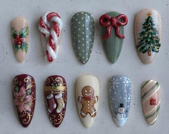 May include: Ten almond-shaped press-on nails featuring Christmas designs including a candy cane, a gingerbread man, a snowman, a Christmas tree, a red bow, poinsettia flowers, stockings, and gift boxes in red, green, white, and brown.
