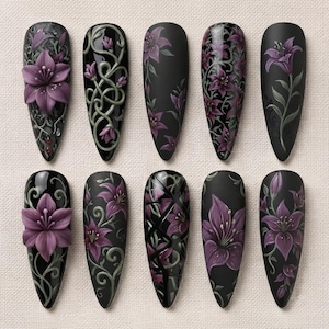 May include: A set of ten almond-shaped artificial nail tips featuring a black base color. The designs include three-dimensional purple lily flowers, intricate green vine patterns, and geometric black lines painted over the dark surface.