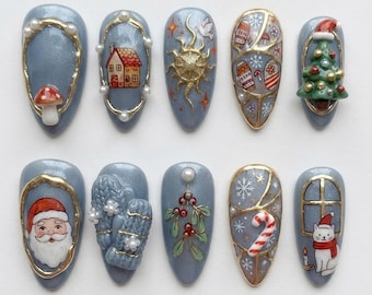 May include: A set of ten almond-shaped press-on nails with a shimmery blue base. Designs include a mushroom, a house, a gold sun, winter patterns, a Christmas tree, Santa Claus, blue mittens, mistletoe, a candy cane, and a cat.
