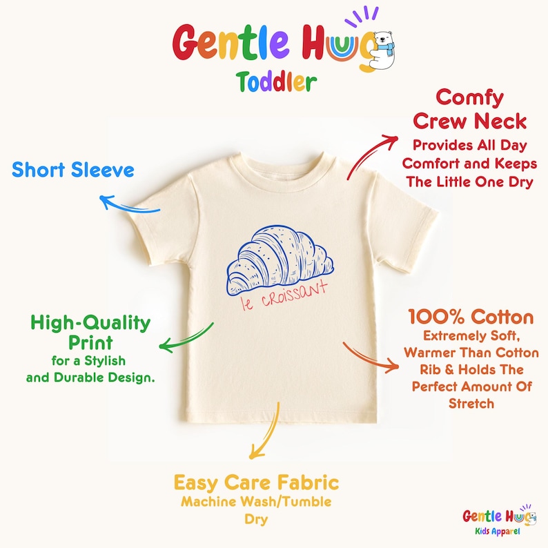May include: Cream-colored toddler t-shirt with a blue croissant graphic and the text "le croissant." The shirt features a crew neck and short sleeves. Made of 100% cotton, the shirt is designed for easy care and a stylish, durable design.