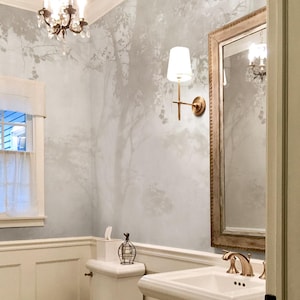 May include: A white ceramic mug with a black handle and the text "But First, Coffee" in a black, bold font. The mug is on a white surface.