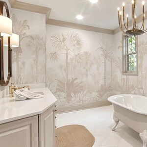 May include: A bathroom with a tropical theme. The walls feature a beige palm tree mural. A white bathtub with claw feet sits near a window. A beige oval rug is on the white tiled floor. A vanity with a mirror and sconces is on the left.