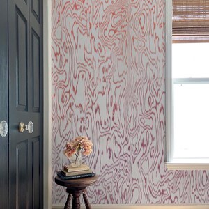 May include: Wallpaper featuring a white background with a repeating coral-colored organic, wavy, wood-grain pattern. The design covers the wall surface, creating a fluid, continuous visual effect across the vertical space of the room.