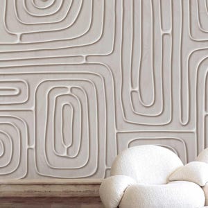 May include: An off-white wall featuring a repeating pattern of curved lines and geometric shapes, creating a textured effect. The design resembles a maze or labyrinth. A white, rounded armchair is placed in front of the wall, enhancing the modern decor.