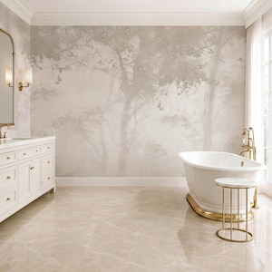 May include: A bathroom featuring a white freestanding bathtub with gold hardware, a white vanity cabinet with gold handles, and a small round side table with a white top and gold frame. The wall displays a large mural of a forest in muted beige tones.