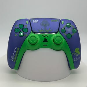 May include: A custom PlayStation 5 controller in purple and green. The controller features green buttons and accents, with Japanese text and graphics. The top section is purple with the number "001" printed on it.