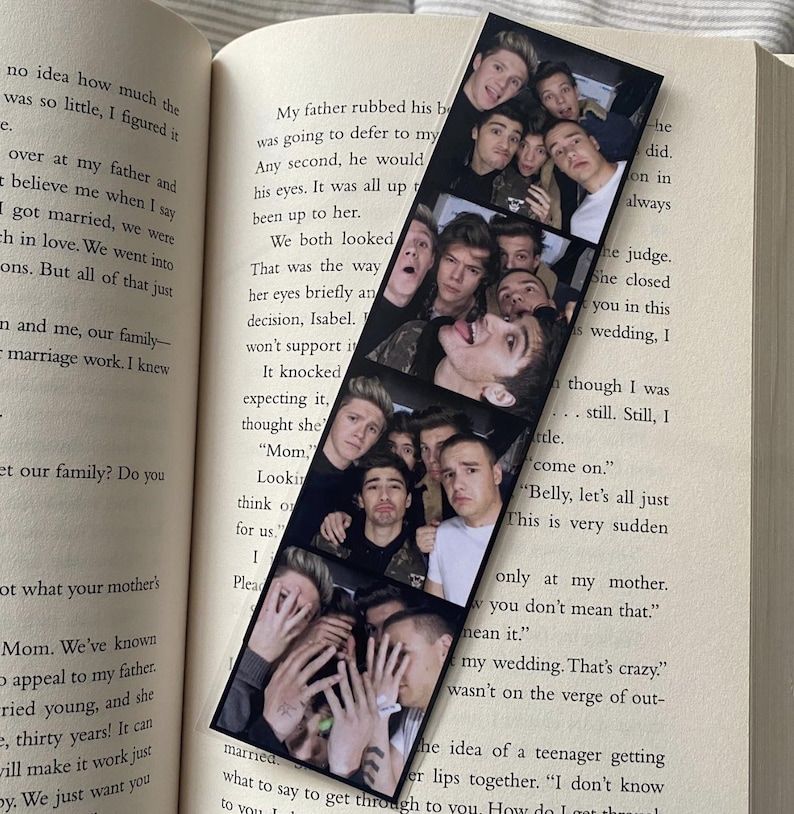 May include: A black and white photo strip bookmark featuring a group of young men smiling and posing for a photo. The bookmark has a white border and is printed on a black background.