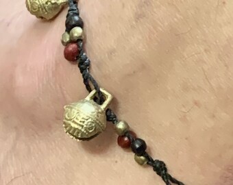 Tibetan Anklet Bhutan Temple Bells. Knotted Black cord.Brass Bells with tiny red, brass and wood beads. Size adjusts. Waterproof.Bells ring.