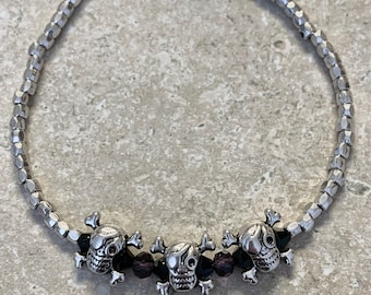 Anklet pirates. Silver pirate beads with black, silver and dark purple glass beads. Anklet measures 9 3/4” with a 1”extender chain.