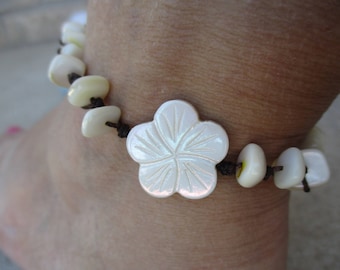 Anklet White Shell Flower Beaded. Hand knotted on Brown Cord. Waterproof. Adjusts in Size to a 10"-14". Flower measures 3/4 inch. Non Metal.