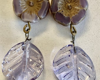 Purple Flower and Leaf Earrings. Handmade fused glass leafs with silver specks. Czech glass flowers. 2” in length. Antique gold ear wires.