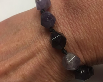 Amethyst Gemstone Bracelet. 8mm of Faceted Amethyst Beads. Hand Knotted in Black cord. Adjusts in Size from 7 “ up to 10”. Waterproof.