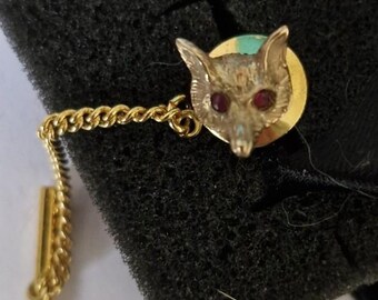 Alfinete de gravata em formato de cabeça de raposa, dourado com olhos de rubi.