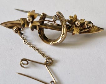 Broche de ferradura dourada