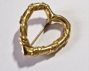 Broche dourado em forma de coração