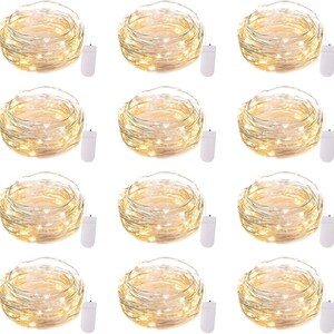 May include: A collection of twelve sets of warm white LED string lights. Each set is coiled and connected to a small white battery pack. The lights are ideal for decorative purposes.