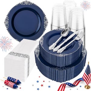 May include: A party supply set featuring navy blue plastic plates with silver filigree rims, clear plastic cups, white napkins with silver borders, and silver-toned plastic cutlery. Includes two firework-themed pops and a small American flag.