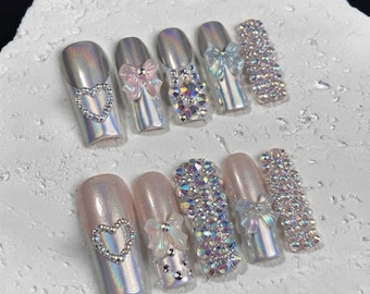 Zilverkleurige chroom plaknagels, holografische nagels, nagels met strass strikjes, luxe bling nagels, Y2K chroom nagels, glamour plaknagelset