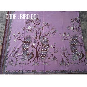 Könnte beinhalten: Ein hellvioletter Stoff mit einem sich wiederholenden Muster aus drei Pfauen mit detaillierten Schwanzfedern, die zwischen stilisierten Bäumen und Blumen stehen. Der Text CODE : BIRD 001 ist oben links auf dem Stoff weiß aufgedruckt.