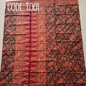 Könnte beinhalten: Ein rechteckiges Stoffstück mit dem Text CODE: T001. Das Textil zeigt einen dunklen Hintergrund mit komplexen roten Blumenmustern und ein zentrales vertikales Paneel, das mit sich wiederholenden dreieckigen Motiven in Rot- und Cremetönen verziert ist.