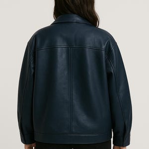 Puede incluir: Chaqueta azul marino con cuello cl&aacute;sico y pu&ntilde;os abotonados. La chaqueta tiene un corte entallado y presenta costuras verticales en la espalda. La prenda est&aacute; hecha de un material liso similar al cuero.