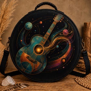 May include: A round black shoulder bag featuring a vibrant graphic print of an acoustic guitar surrounded by swirling cosmic nebulae, glowing stars, and colorful planets. The bag includes a top handle and adjustable black side straps with metal clips.