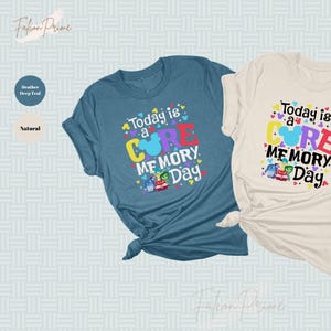 May include: Two t-shirts with a blue and a beige color. The shirts have a graphic design with the text "Today is a CORE MEMORY Day" and a cartoon image of a Mickey Mouse head with the characters from the movie Inside Out.