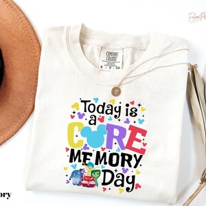 May include: Ivory-colored t-shirt with the text "Today is a CORE MEMORY Day" in colorful letters and Disney-themed graphics. The shirt features the Comfort Colors brand tag and a gold necklace.