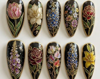 May include: Ten black, almond-shaped artificial nails with intricate floral designs. Each nail features a different flower, including a tulip, magnolia, and rose, with gold outlines and accents. The flowers are painted in various colors, such as pink, white, and red.