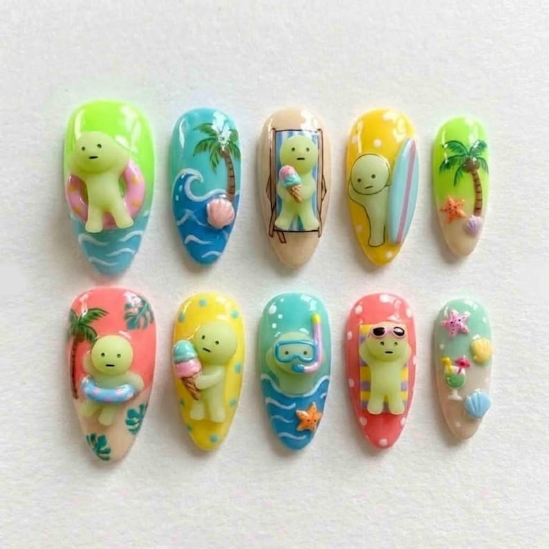 May include: A set of ten artificial nails with a summer theme. Each nail features a different design, including a small figure with a beach theme, palm trees, waves, and beach accessories. The nails are painted in various bright colors.