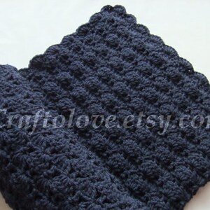 May include: A navy blue crocheted baby blanket with a scalloped edge.