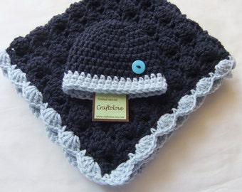 May include: A navy blue crocheted baby blanket with a matching hat. The blanket has a light blue crocheted border and the hat has a light blue crocheted brim. A blue button is sewn on the hat.