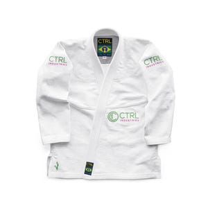 Puede incluir: Gi blanco de Jiu-Jitsu con logotipo CTRL Industries verde y amarillo en el pecho y las mangas. El Gi tiene un parche de la bandera brasileña verde y amarillo en el cuello.