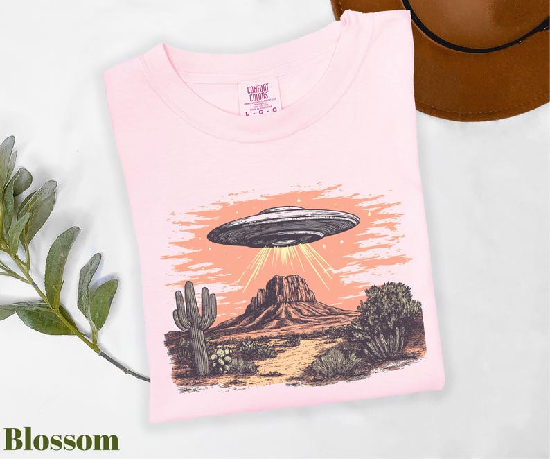 a pink shirt with an image of a flying saucer on it